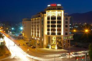 un bâtiment avec un panneau de néon en haut de celui-ci la nuit dans l'établissement Hotel VEGA Sofia, à Sofia