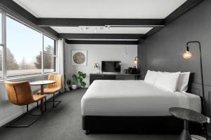肯图巴Echo Point Discovery Motel的一间带床、桌子和电视的卧室