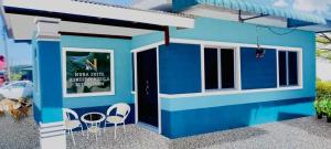 a blue house with white chairs in front of it at Tasik Biru Homestay Kuala Terengganu in Marang