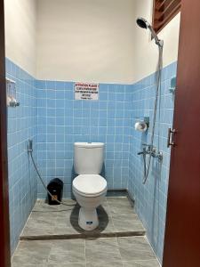 a bathroom with a toilet in a blue tiled bathroom at Simon Homestay in Sanur +18 photos