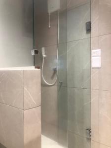 a shower with a glass door in a bathroom at Studio equipado e decorado no Centro Balneário Camboriú in Balneário Camboriú