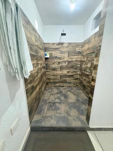 a bathroom with a shower with wooden walls at Departamento Suite familiar frente a las riberas in Culiacán