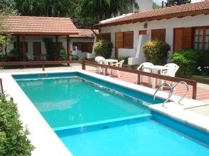 a swimming pool with chairs and a house at El Agora in Villa General Belgrano