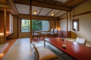 uma sala de estar com uma mesa e cadeiras de madeira em Fujiya em Niigata