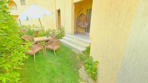 a patio with a table and chairs and an umbrella at استديو فرش فندقي مجهز بالكامل بورتو جولف مارينا in El Alamein