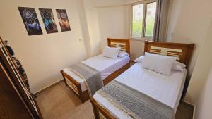 a small room with two beds and a window at استديو فرش فندقي مجهز بالكامل بورتو جولف مارينا in El Alamein