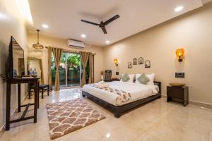 a bedroom with a bed and a table and a desk at Mysa by De Soul Santé in Morjim