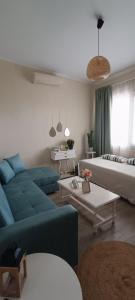 a living room with a blue couch and a bed at Dream house Peramos in Nea Peramos