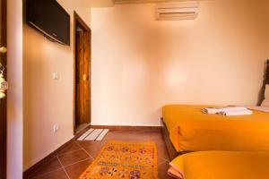 Habitación pequeña con 2 camas y TV. en Hotel Atlas, en Marrakech