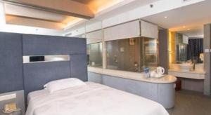 a bedroom with a large bed and a kitchen at Friendship Hotel in Shenzhen +222 photos