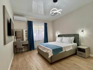 a bedroom with a bed and a desk and a window at MaRailiS Port Apart Mangalia in Mangalia