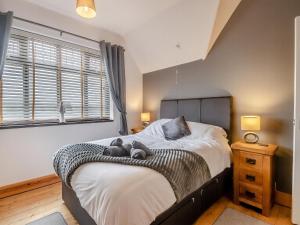 a bedroom with a bed with two teddy bears on it at Beachside House in Scratby +11 photos