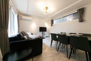 a living room with a couch and a table and chairs at GaiarS8 in Sapporo