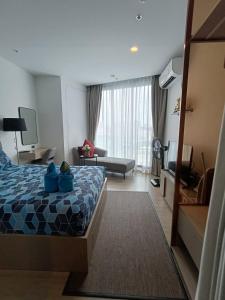 a hotel room with a bed and a living room at The Edge Central Pattaya Tops Luxury New Project in Ban Nong Chaeng
