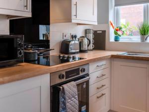 a kitchen with white cabinets and a stove top oven at Ay Come Inn in York +15 photos