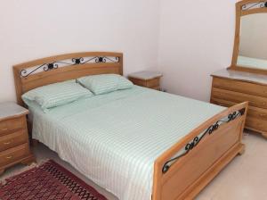 um quarto com uma cama, 2 cómodas e um espelho em Maison Karim em Nabeul