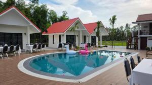 Una piscina en un resort con una balsa de fideos de piscina de color rosa en Baan Home Resort, en Kalasin