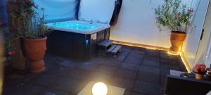 a balcony with a hot tub and two potted plants at Nueva suite jacuzzi relax beach & mountain in Palamós