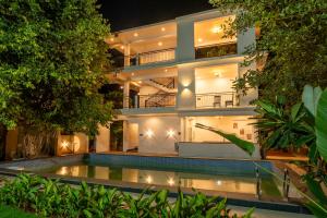 an apartment building with a swimming pool at night at Mysa by De Soul Santé in Morjim