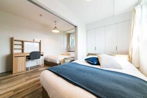 a bedroom with a bed and a desk with a mirror at Twinberry CHITOSE in Chitose