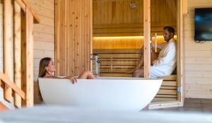 a man and a woman sitting in a bath tub at Apartmaji Smogavc in Zreče
