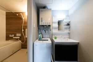 a small bathroom with a sink and a washing machine at Twinberry CHITOSE in Chitose +110 photos