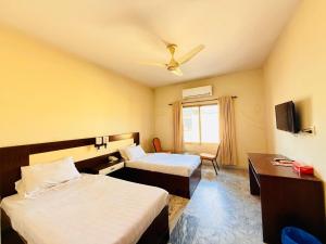 a hotel room with two beds and a tv at Pameer Hotel Mingora in Mingora +14 photos