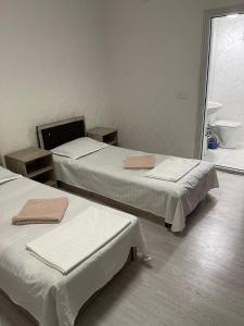 een kamer met 3 bedden en een badkamer bij Sohil Hostel in Tasjkent