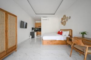 a bedroom with a bed and a desk at De Luxora Villa Canggu in Kerobokan