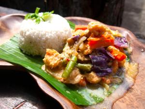 un plato de comida con arroz y pollo y verduras en Funky Place, en Lovina