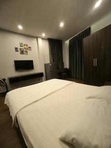 a hotel room with a large bed and a television at xh apartment in Danang
