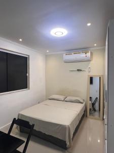 a bedroom with a bed and a flat screen tv at Suíte 3 Residencial in Nova Iguaçu