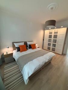 een slaapkamer met een groot bed met oranje kussens bij FeWo Sonnenberg in Chemnitz +26 foto's