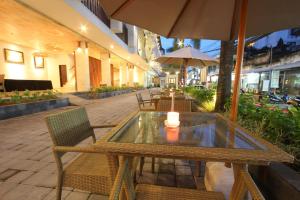 a patio with a table and chairs and an umbrella at Grand La Walon Hotel in Legian