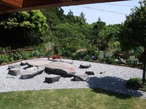 a garden with rocks in the middle of a yard at Yakushima Pension Ichigoichie in Yakushima