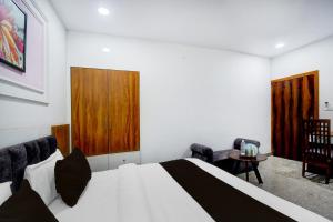 a bedroom with a bed and a table and chairs at Super Hotel O Maruti in Jaipur +22 photos