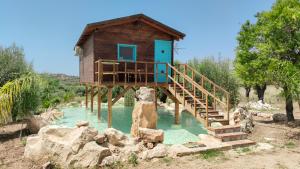 a tree house on a bridge over a river at Masseria Usamborgia in Noto
