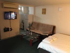 a hotel room with a couch and a bed and a table at City Center apartment in Podgorica +8 photos