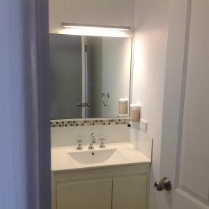 een badkamer met een wastafel en een spiegel bij Tannum Sands Hotel / Motel in Tannum Sands