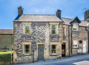 an old stone house on the side of a street at Cosy cottage in the heart of Bakewell in Bakewell
