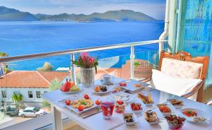 a table with food on a balcony with a view of the ocean at Hotel Sonne - Adults Only in Kaş