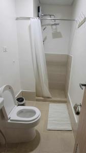 a white bathroom with a toilet and a shower at Leaf residences 2bedroom Muntinlupa in Manila +8 photos