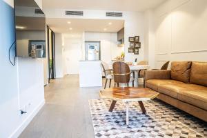 a living room with a couch and a table at Riverside Reverie French Luxury at BNE Casino in Brisbane