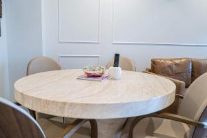 a round wooden table with chairs around it at Riverside Reverie French Luxury at BNE Casino in Brisbane +75 photos