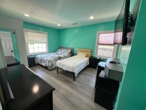 英格尔伍德Room with pool view close to Sofi Stadium and LAX的一间卧室设有绿色的墙壁、一张床和一张书桌