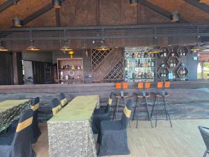 a restaurant with tables and chairs and a bar at Lake View Fishing Camp in Kaeng Krachan