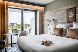 Una habitación de hotel con una cama grande y un balcón. en Thalazur Carnac, en Carnac 77 fotos más