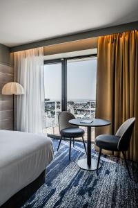 Una habitación de hotel con una cama, una mesa y sillas. en Thalazur Carnac, en Carnac 41 fotos más