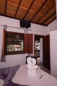 a room with a bed with a white glove on it at Pousada do Mineiro in Trancoso