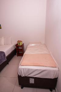 two beds sitting next to each other in a room at Pousada do Mineiro in Trancoso